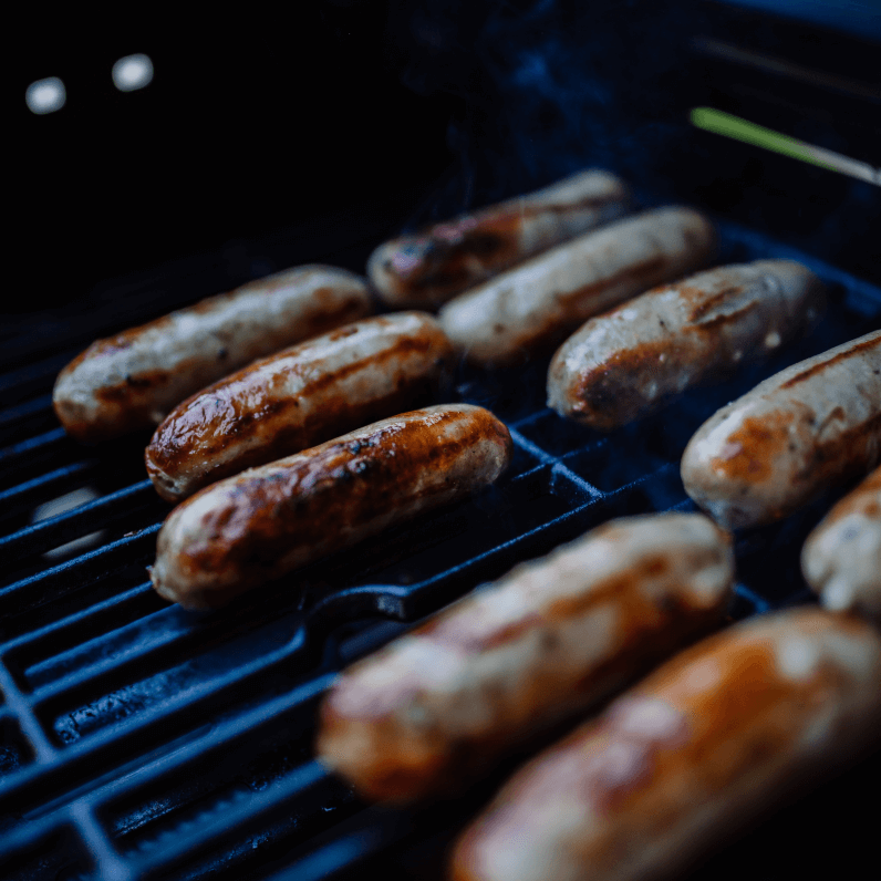 A grill pan full of oven cooked sausages.