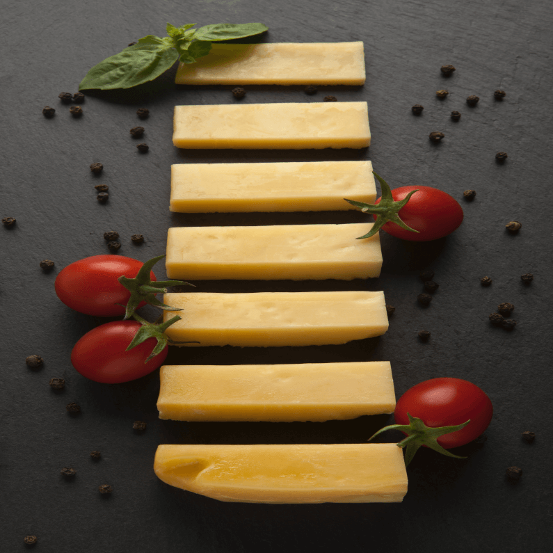 A slate with pieces of cheddar cheese on it.